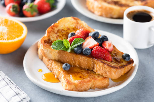 French toast with fresh berries and sweet syrup stock photo