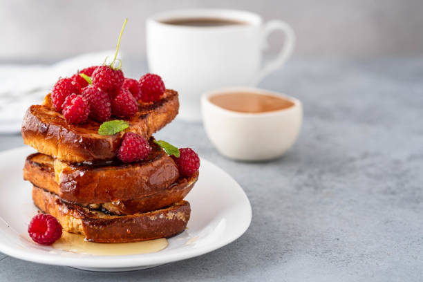 French toasts, French toasts made of sliced brioche with fresh raspberries, honey and mint. Delicious breakfast or dessert stock photo