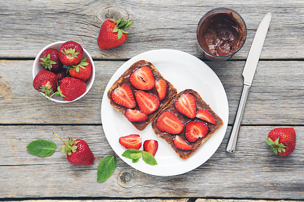 French toasts with chocolate and strawberry on wooden table stock photo