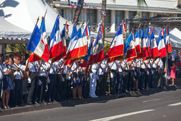 Saint Denis, La Réunion - July 14 2016: Veterans from the French military parading with french flags of during Bastille Day.
