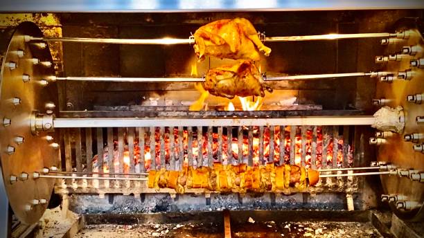 fresh and hot rotisserie chickens spinning on a spit at the mercato centrale firenze. stock photo