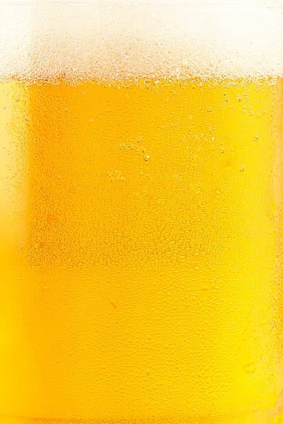 Fresh Beer Macro shot of blonde beer in glass  frothy drink stock pictures, royalty-free photos & images