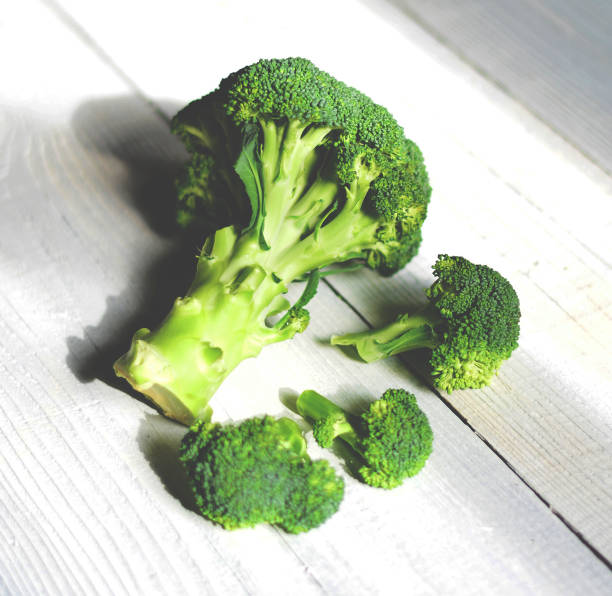 Fresh brocolli on white table  broccoli rabe stock pictures, royalty-free photos & images
