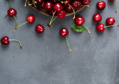 Fresh cherry on black slate table Ripe sweet berries in the droplets of water in a gray background with copy space