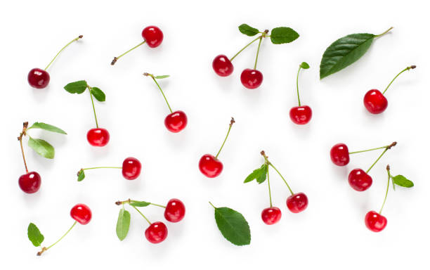 Fresh cherry with green leaves isolated on white background Lot fresh cherry with green leaves isolated on white background, Set of red ripe cherries. Beautiful food Background with scattered cherries. Top view. Flat lay. cherry stock pictures, royalty-free photos & images