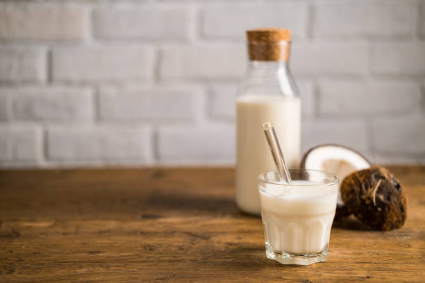 Fresh coconut milk in glass bottle, vegan non dairy healthy drink. stock photo