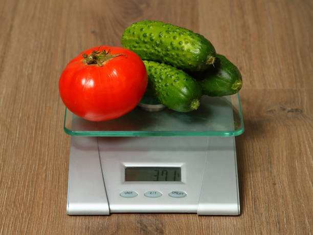 Fresh cucmbers and tomato on the scales. stock photo