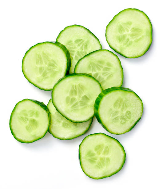 Fresh cucumber slices, isolated on white background Fresh cucumber slices, isolated on white background. Close up shot of cucumber, arrangement or pile. cucumber stock pictures, royalty-free photos & images