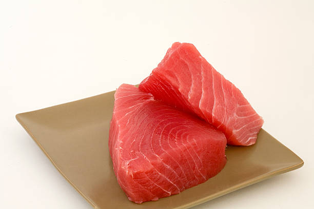Fresh cut Ahi on a square tan plate ready to cook stock photo