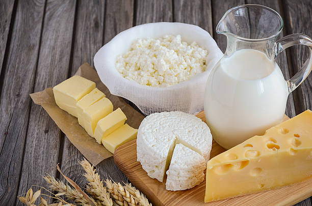 Fresh dairy products - milk, cheese, butter and cottage cheese Fresh dairy products - milk, cheese, butter and cottage cheese with wheat on rustic wooden background, selective focus, copy space calcium stock pictures, royalty-free photos & images