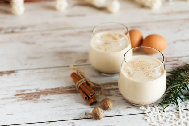 Fresh eggnog with cinnamon and nutmeg for christmas holiday. Fresh eggnog with cinnamon and nutmeg for christmas holiday with christmas decorations on wooden background.. cream dairy product photos stock pictures, royalty-free photos & images