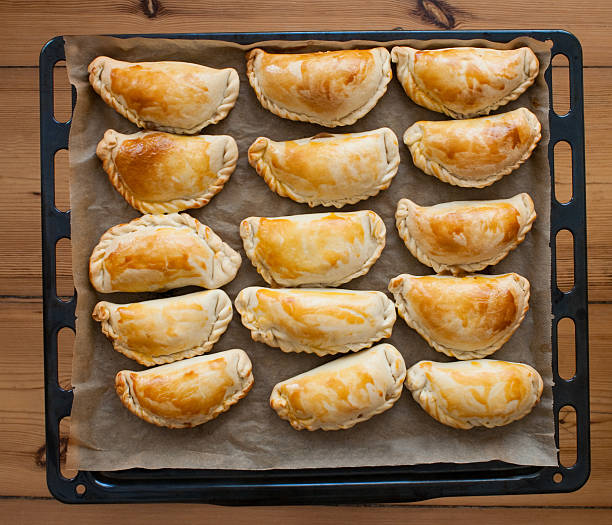fresh empanadas - traditional food  on baking tray fresh empanadas - traditional food  on baking tray argentina food stock pictures, royalty-free photos & images