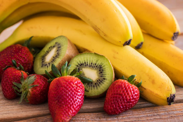 Fresh fruits on table, banana, kiwi and strawberries stock photo
