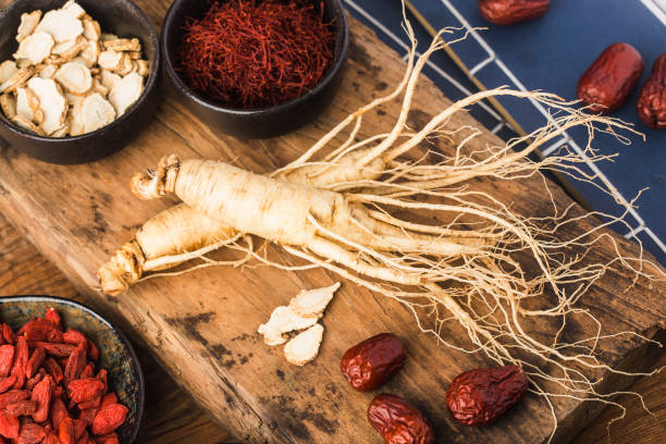 Fresh ginseng and dry slices stock photo