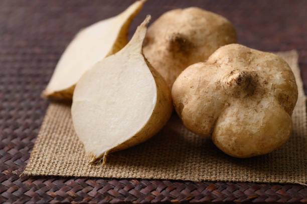 Fresh jicama or yam bean Fresh jicama or yam bean. Jicama can be eaten raw or cooked, The taste are crisp, juicy, moist, and slightly sweet jicama stock pictures, royalty-free photos & images