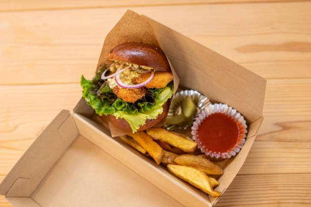 Fresh made take away hamburger with onion rings in a take away box stock photo