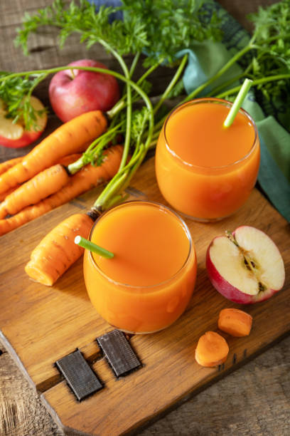 Fresh natural juice, healthy food concept. Glass jar of fresh apple and carrot juice on a wooden rustic table. stock photo