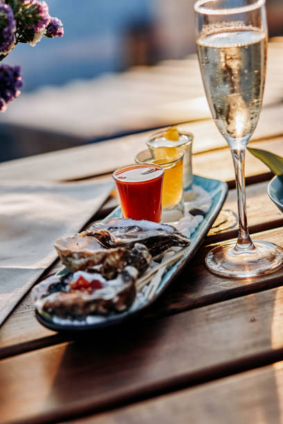 Fresh open oysters with a glass of chilled prosecco wine and set of shoot alcoholic cocktails served on table. Seafood delicios stock photo
