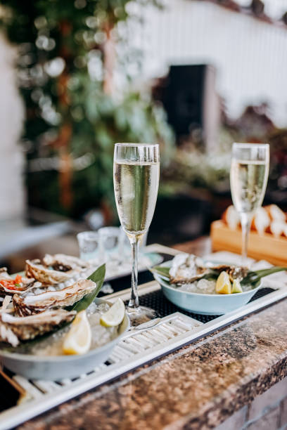 Fresh open oysters with a glass of chilled prosecco wine served on table. Seafood delicios stock photo