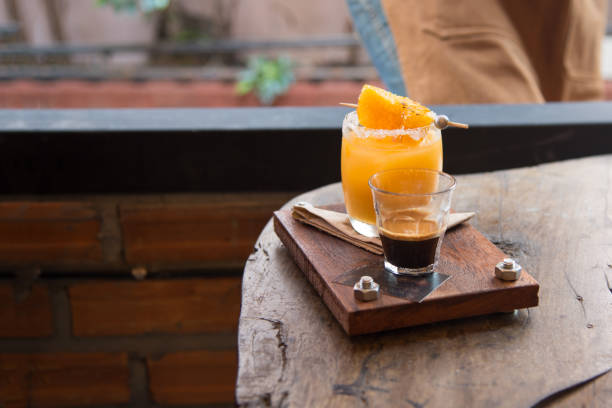 Fresh orange juice and intense Colombia coffee on wood tray served with orange grill stock photo