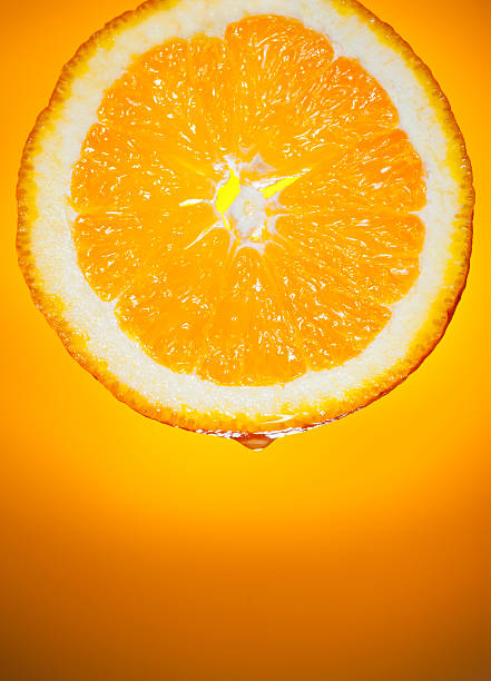 fresco ininterrupto fatia de laranja, sumo de fruta em fundo do nascer do sol - spot light orange imagens e fotografias de stock