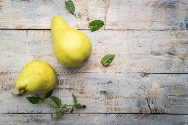 Fresh organic pears on old wood. Fruit background. Pear autumn harvest Fresh organic pears on old wood. Fruit background. Pear autumn harvest. pear stock pictures, royalty-free photos & images