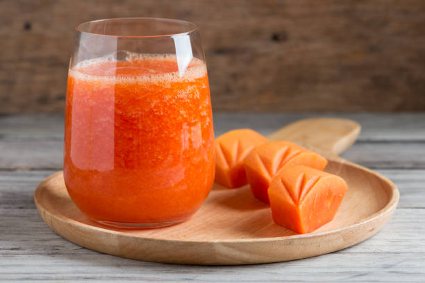 Fresh papaya smoothie juice in glass Fresh papaya smoothie juice in glass on wooden background papaya smoothie stock pictures, royalty-free photos & images