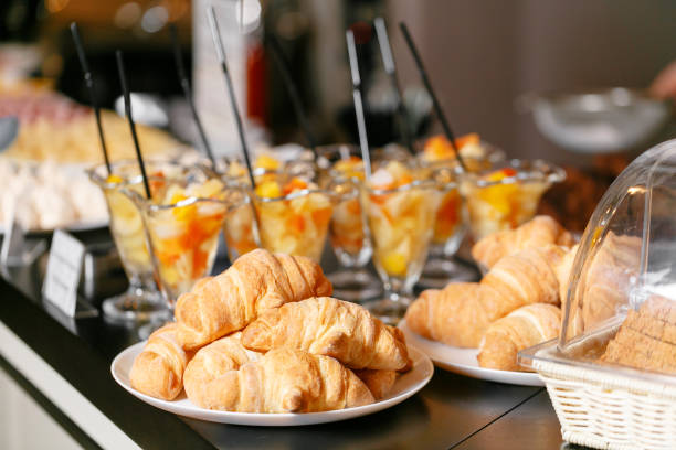 Fresh pastry, crispy morning croissants, hotel breakfast buffet. Dessert fruit cocktail in cups stock photo