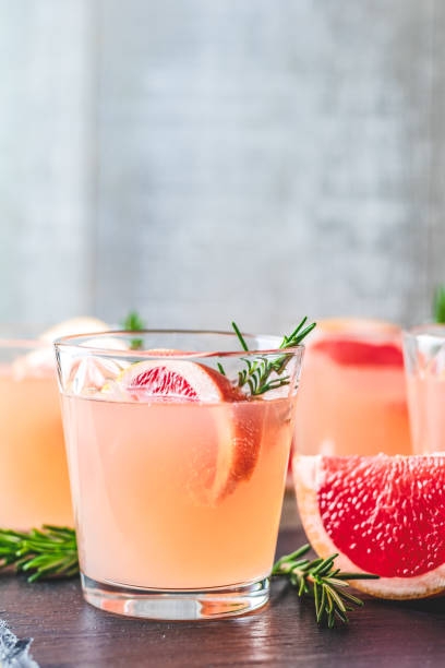 Fresh pink alcoholic cocktail with grapefruit, ice and rosemary stock photo