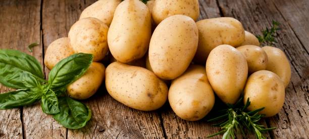 Fresh potatoes on wooden background stock photo