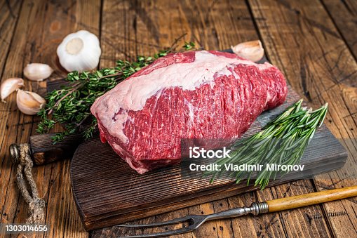 istock Fresh Raw brisket beef meat prime cut on a wooden  board with herbs. wooden background. Top view 1303014656