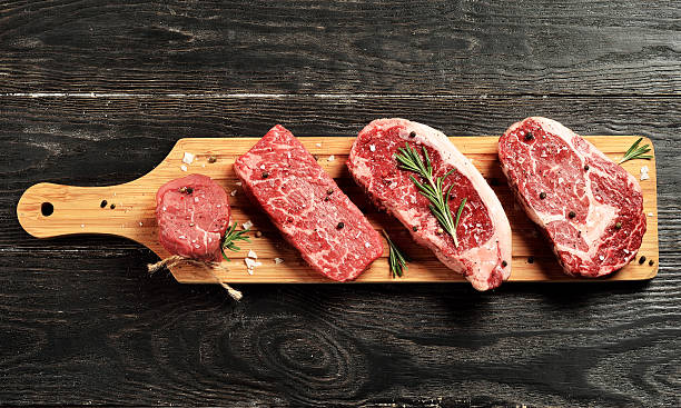 Fresh raw Prime Black Angus beef steaks on wooden board Fresh raw Prime Black Angus beef steaks on wooden board: Tenderloin, Denver Cut, Striploin, Rib Eye cut of meat stock pictures, royalty-free photos & images