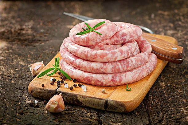 Fresh raw sausage on the old wooden background Fresh raw sausage on the old wooden background sausage stock pictures, royalty-free photos & images