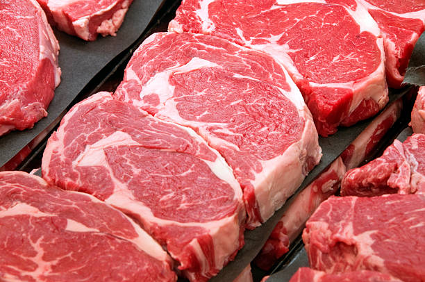 fresh ribeye steaks at the butcher shop - rauw stockfoto's en -beelden