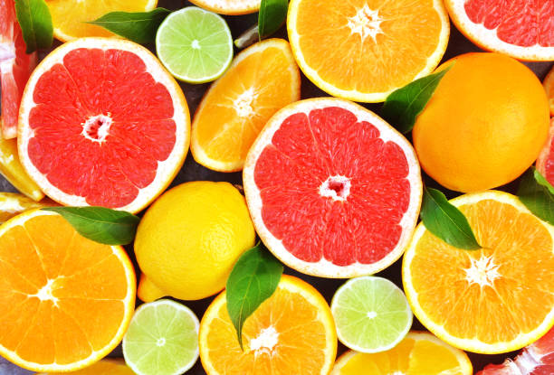 Fresh ripe sweet citrus fruits colorful background Fresh ripe sweet citrus fruits colorful background: orange, grapefruit, lime, lemon citrus fruit stock pictures, royalty-free photos & images
