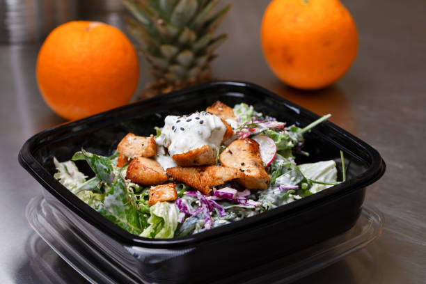 Fresh salad meal packed in a plastic container ready to eat - Healthy takeaway food and eating concept Fresh salad meal packed in a plastic container ready to eat - Healthy takeaway food and eating concept. Shot in a real healthy fast food kitchen, ready for delivery. food state stock pictures, royalty-free photos & images