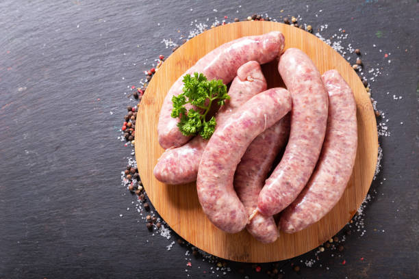 Fresh sausages on a chopping board, top view stock photo