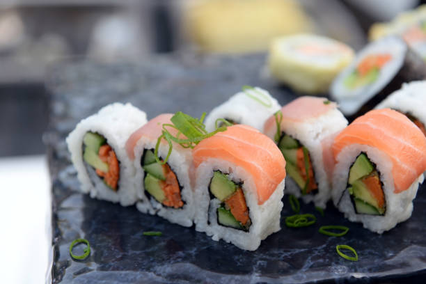 Fresh sushi on black plate in motion. stock photo