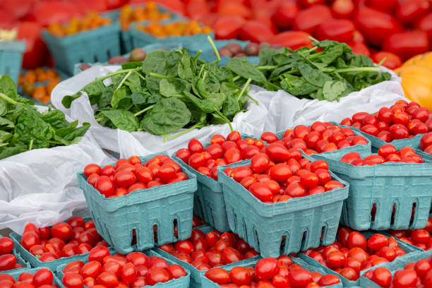 Fresh tomatoes and spinach at a local farmer's market stock photo