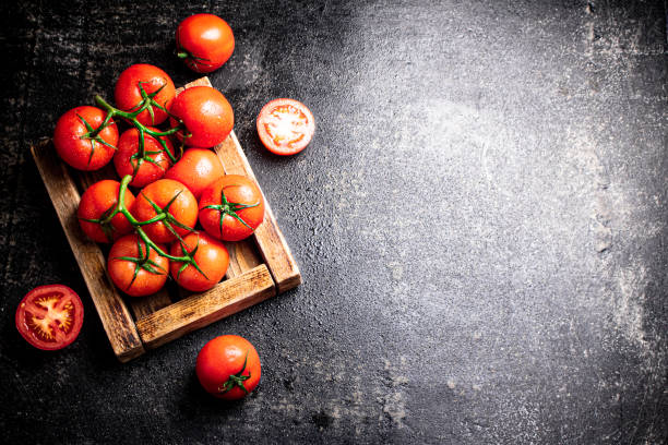 Fresh tomatoes on a wooden tray. stock photo