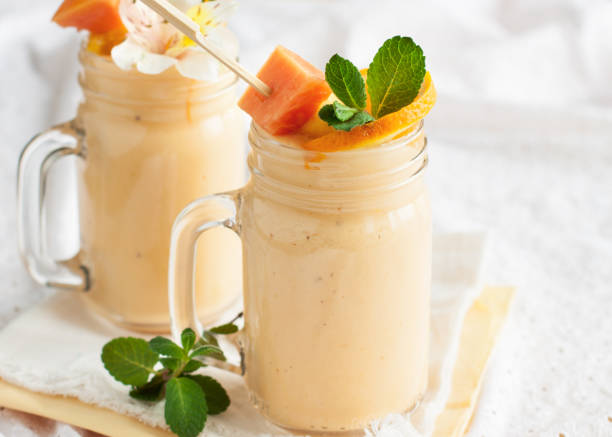 Fresh tropical smoothie with ingredients Homemade smoothie with tropical fruits: mango, banana, pineapple, papaya in glass Mason jar. Healthy juicy vitamin drink papaya smoothie stock pictures, royalty-free photos & images