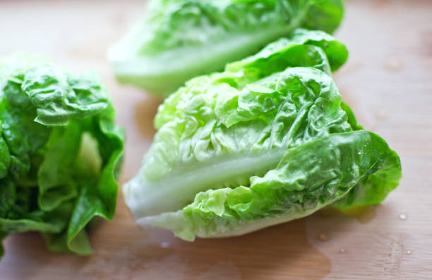 Fresh washed bundle of Romaine lettuce on the wooden cutting board stock photo