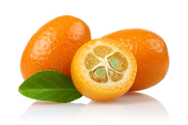 Fresh whole and half kumquat fruit with leaf Fresh kumquats isolated on white background kumquat stock pictures, royalty-free photos & images