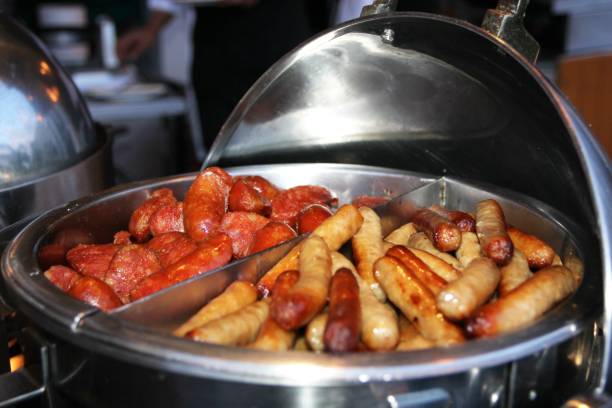 Freshly grilled hotdogs served at the breakfast bar of a buffet station stock photo