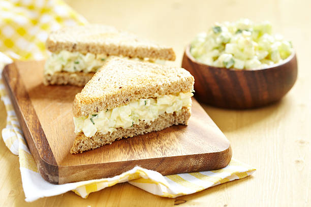 Freshly prepared egg salad sandwich Egg salad sandwich with cucumber, chive and cream cheese 7 grain bread photos stock pictures, royalty-free photos & images