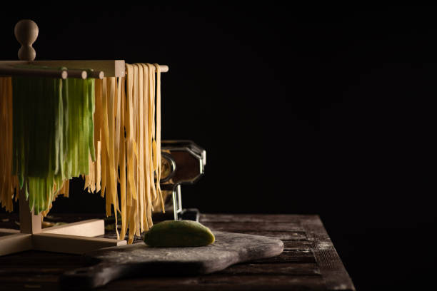 Freshly prepared Tagliatelle paste is dried on a wooden drier. Traditional italian cuisine stock photo