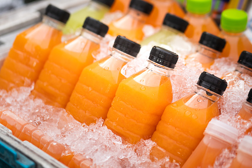 Freshness fruits juice in bottles, cooling with ice. Food and drink photo. Close-up and selective focus at once.