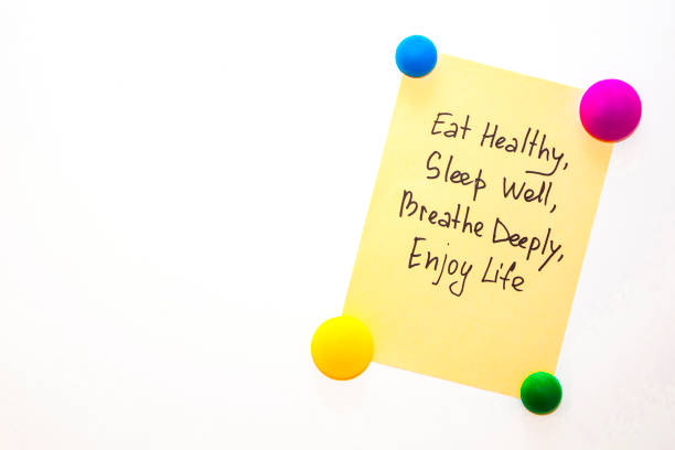 Fridge note with the text about wellness: Eat healthy, sleep well, breathe deeply, enjoy life stock photo