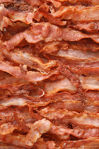 Fried bacon background Top view of fried bacon stripes bacon photos stock pictures, royalty-free photos & images