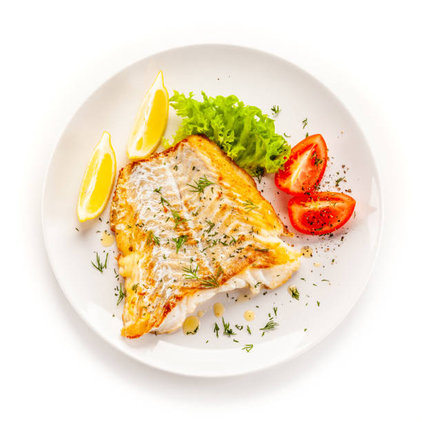 stekt torskfilé och grönsaker på vit bakgrund - tallrik med fisk bildbanksfoton och bilder